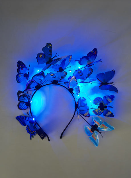 Ein Schmetterling-Haarreif mit LED, verziert mit blauen Kunstschmetterlingen und kleinen blauen LED-Lichtern, ideal als Ergänzung zu deinem Schmetterlingskostüm, präsentiert vor einem schlichten Hintergrund.