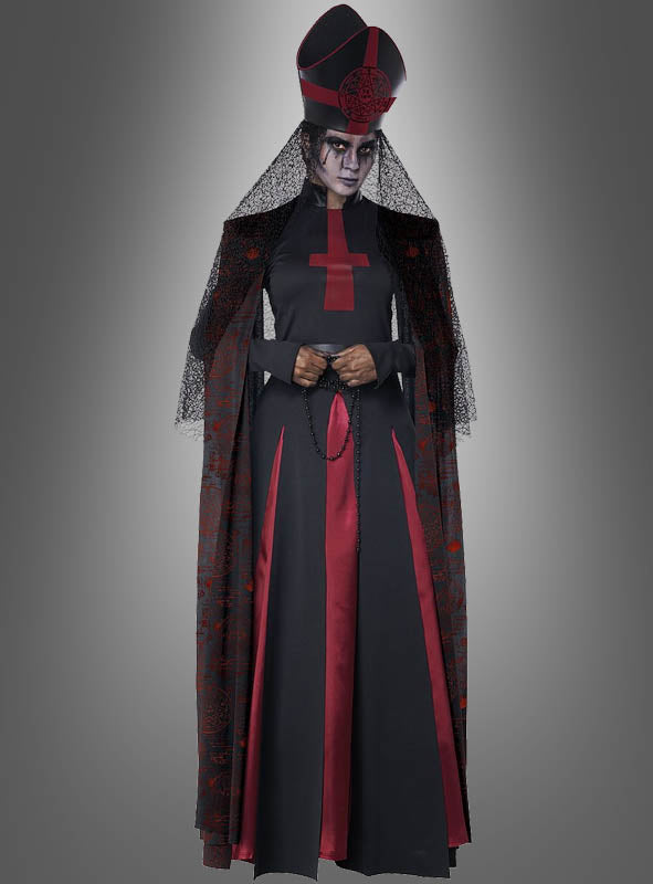 Eine Person in einem schwarz-roten, von einer Bischöfin inspirierten Kostüm mit Schleier, großem Kopfschmuck und einem roten Kreuz auf dem Kleid, die einen Rosenkranz in der Hand hält – dieses auffällige „Dunkle Priesterin“-Halloween-Kostüm hebt sich deutlich von einem grauen Hintergrund ab.