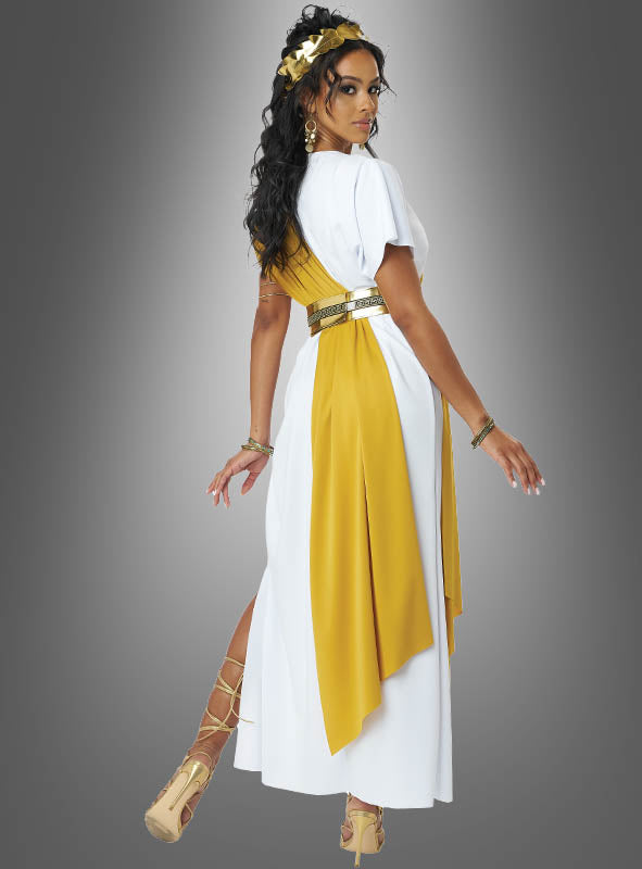 Eine Frau, die die „Göttliche römische Toga Damen“ mit einer goldenen Schärpe, goldenen Accessoires und einem goldenen Kopfschmuck trägt, steht vor einem grauen Hintergrund mit Farbverlauf und blickt über die Schulter.