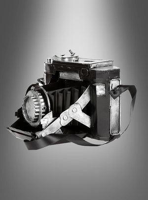 Eine Vintage-Fotokamera-Dekoration aus Blech mit Trageriemen, präsentiert vor einem grau abgestuften Hintergrund, eignet sich ideal als Vintage-Dekorationsstück oder als authentische Vintage-Fotokamera für jedes Kostüm-Ensemble im Stil der 20er Jahre.