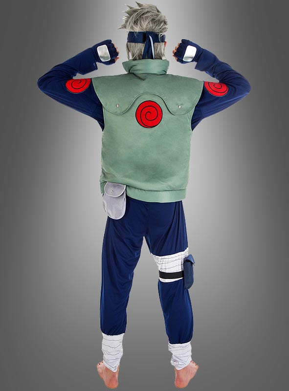 Eine Person in einem Kostüm im Anime-Stil, bestehend aus einer blauen Hose, einer grünen Weste und roten Wirbel-Symbolen, steht barfuß mit dem Rücken zur Kamera vor einem grauen Hintergrund, was an das Kakashi-Kostüm aus dem Naruto-Cosplay erinnert.