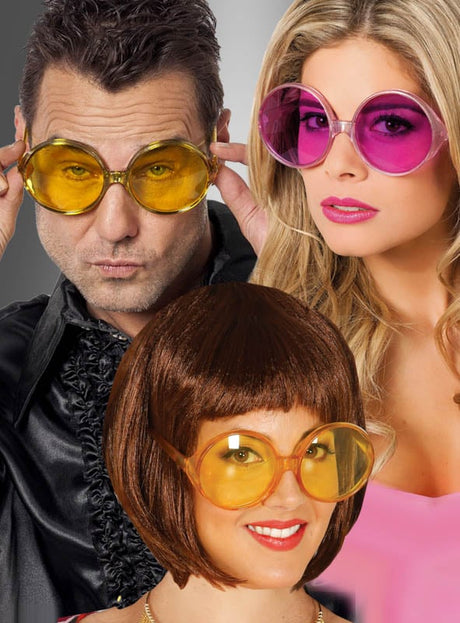 Drei Erwachsene posieren vor einem neutralen Hintergrund und tragen jeweils eine 70er-Partybrille mit großen Gläsern – eine übergroße, runde Sonnenbrille, die sich ideal für jedes Hippie-Kostüm oder als auffälliges Accessoire für eine Schlagerparty eignet. Zwei davon haben gelbe Gläser, während eine mit rosa Gläsern ausgestattet ist.