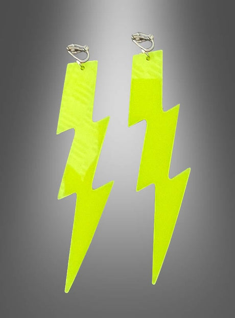 Ein Paar neongelbe, blitzförmige Ohrringe mit silbernen Clipverschlüssen vor einem grauen Farbverlaufshintergrund – diese „80er Clip-Ohrringe Neon Blitz oder Sterne“ sind die perfekten Neon-Ohrringe, um Ihrer 80er-Jahre-Schmuckkollektion einen auffälligen Akzent zu verleihen.