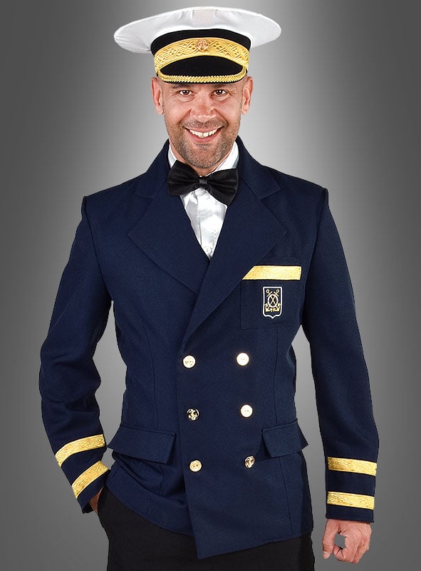 Ein Mann, der die „Kapitän-Kostüm-Jacke für Herren“ trägt – eine marineblaue Zweireiherjacke mit goldenen Verzierungen –, kombiniert mit einem weißen Hemd, einer schwarzen Fliege und einer klassischen weißen Kapitänsmütze, steht lächelnd vor einem grauen Hintergrund. Das ideale Outfit für maritime Veranstaltungen oder als authentisches Kapitänskostüm.