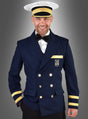 Ein Mann, der die „Kapitän-Kostüm-Jacke für Herren“ trägt – eine marineblaue Zweireiherjacke mit goldenen Verzierungen –, kombiniert mit einem weißen Hemd, einer schwarzen Fliege und einer klassischen weißen Kapitänsmütze, steht lächelnd vor einem grauen Hintergrund. Das ideale Outfit für maritime Veranstaltungen oder als authentisches Kapitänskostüm.