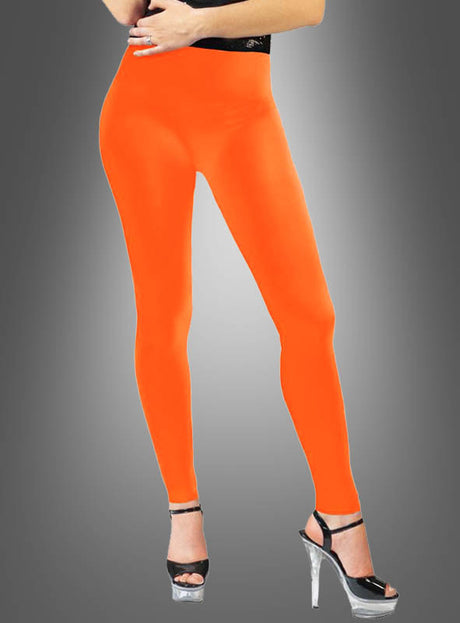 Eine Person trägt die „Blickdichte Leggings Neon im 80er-Jahre-Look“ in leuchtendem Orange, kombiniert mit schwarzen Sandalen mit hohen Absätzen, und steht vor einem grauen Hintergrund mit Farbverlauf – ein auffälliger Look im Stil der 80er Jahre.