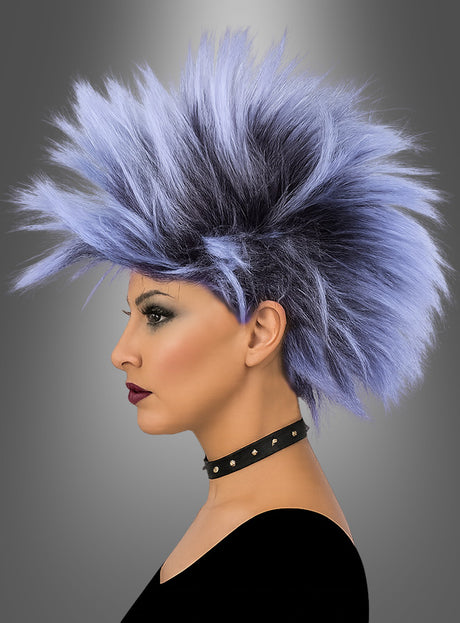 Eine Person im Profil präsentiert die „Punkerin“-Perücke mit Igel-Frisur – eine auffällige Perücke im Stil der 80er Jahre mit dramatisch gestylten, lavendelfarbenen und schwarzen Haaren, auffälligem dunklem Make-up, einem mit Nieten besetzten Halsband und einem schwarzen Oberteil vor einem grauen Hintergrund mit Farbverlauf, die eine selbstbewusste Ausstrahlung vermittelt.