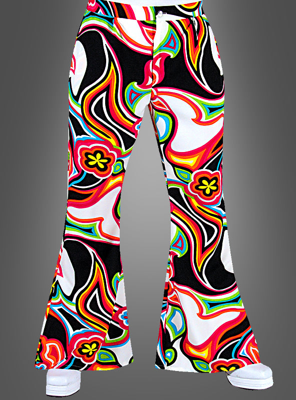 Eine Person trägt die Herren-Schlaghose „Neon Psychodelic“ mit einem farbenfrohen, neonfarbenen Psychedelic-Muster und Schlagbeine auf weißem Hintergrund; teilweise sind weiße Schuhe zu sehen.