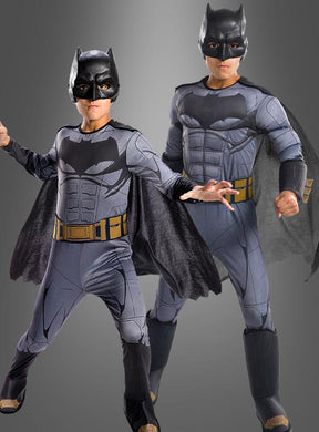Zwei Kinder, die das Batman-Filmkostüm aus „Justice League“ tragen – komplett mit Masken, Umhängen und Ausrüstungsgürteln –, stehen selbstbewusst vor einem grauen Hintergrund mit Farbverlauf. Dieses offizielle DC-Comics-Lizenzprodukt ist ideal für junge Superhelden, die der Justice League beitreten möchten.