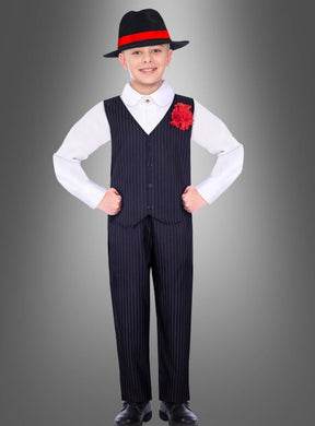 Ein kleiner Junge, der das Mafia-Kostüm „Little Carlo“ trägt – bestehend aus einem klassischen Nadelstreifenanzug, einem weißen Hemd, einer roten Blume am Revers und einem schwarzen Hut mit rotem Band –, steht selbstbewusst vor einem grau abgestuften Hintergrund. Dieses Outfit eignet sich perfekt für jeden Kinderfasching oder als authentisches Mafia-Kostüm für Kinder.