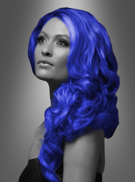 Eine Frau mit langen, welligen, leuchtend blauen Haaren – die mit „Farbiges Haarspray für Karneval“ zu einem lebhaften, festlichen Look gestylt wurden – posiert vor einem grauen Hintergrund mit Farbverlauf; ihr Gesichtsausdruck ist ruhig, während sie leicht nach oben blickt.
