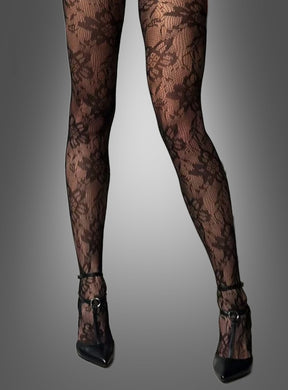 Eine Person, die die „Stilvolle Strumpfhose mit Blumenmuster“ und schwarze Schuhe mit hohen Absätzen trägt und vor einem grauen Hintergrund mit Farbverlauf steht.