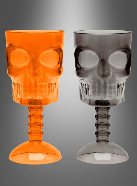 Zwei Halloween-Totenkopf-Weinkelche oder Trinkbecher aus Kunststoff, einer in Orange und einer in Grau, sind nebeneinander vor einem grau verlaufenden Hintergrund abgebildet – perfekt als gruselige Becher für Kleinigkeiten oder als auffällige Tischdekoration für Ihre nächste Halloween-Party.