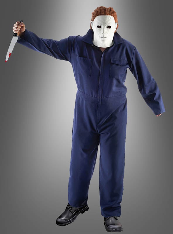 Eine Person, gekleidet in einem „Michael M. Overall Herren“-Halloween-Kostüm, einer weißen Maske und schwarzen Stiefeln, hält ein großes Messer mit roten Flecken auf der Klinge in der Hand und steht vor einem schlichten, grau verlaufenden Hintergrund.