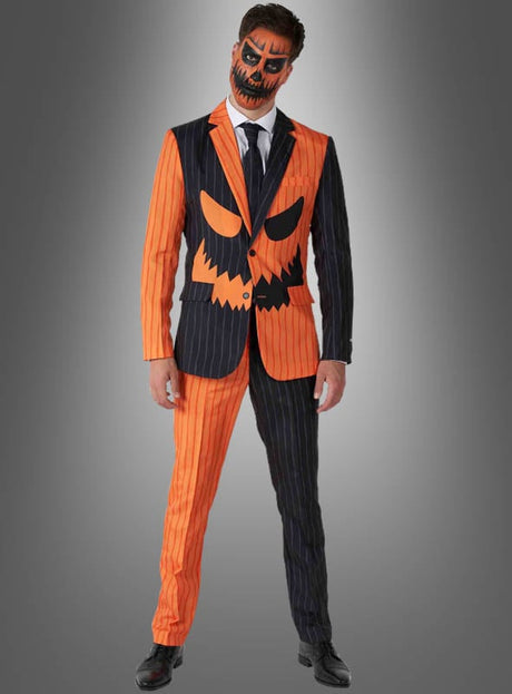 Eine Person, die einen „Kürbis-Anzug“ von Halloween Suitmeister trägt – einen Nadelstreifenanzug mit einem halb orangefarbenen, halb schwarzen Design und Akzenten in Form von Kürbiskopf-Gesichtern – sowie passendes Kürbiskopf-Make-up, vor einem grauen Hintergrund mit Farbverlauf. Ideal für alle, die einen außergewöhnlichen Halloween-Anzug oder einen auffälligen Kürbis-Anzug suchen.