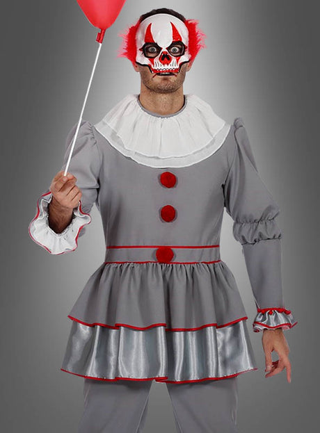 Eine Person im Halloween-Clown-Kostüm – aus grauem Stoff mit roten Verzierungen und Knöpfen – hält einen roten Luftballon in der Hand und trägt eine furchteinflößende weiß-rote Clownmaske mit leuchtend roten Haarbüscheln, während sie vor einem grauen Hintergrund steht. Dieses auffällige Outfit eignet sich perfekt für Halloween oder als unvergessliches Clown-Kostüm für Herren für jede gruselige Veranstaltung.