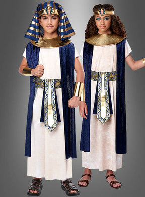 Zwei Kinder stehen nebeneinander vor einem grauen Hintergrund, beide tragen das Ägypter-Kinderkostüm für Jungen und Mädchen. Ihre altägyptischen Kostüme bestehen aus weißen Tuniken, blauen und goldenen Kragen, passenden Kopfbedeckungen und Armstulpen – perfekt für Themenveranstaltungen und erinnern an die Eleganz eines Kleopatra-Kostüms oder die Pracht eines Pharao-Kostüms.