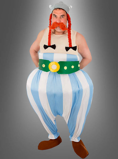 Eine Person, die das „Deluxe Obelix-Kostüm XXL für Erwachsene“ aus der Asterix-Reihe trägt – bestehend aus einem Wikinger-Outfit im Cartoon-Stil mit einem geflügelten Helm, eine rote, geflochtene Perücke, eine blau-weiß gestreifte Hose und einen grünen Gürtel, vor einem grauen Hintergrund – eine ideale Wahl für alle, die ein Obelix-Kostüm XXL oder ein klassisches Herren-Faschingskostüm suchen.