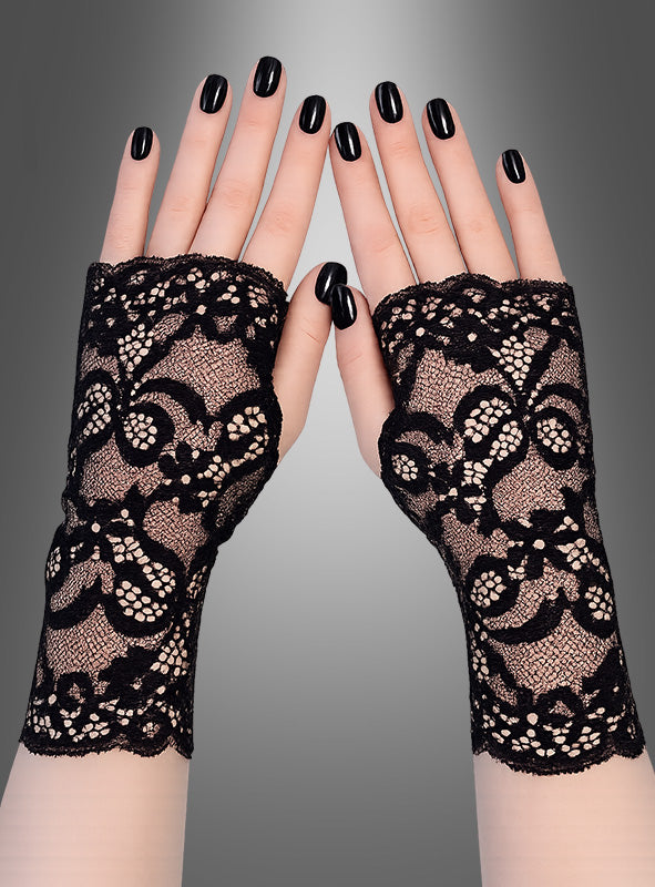 Zwei Hände mit schwarzem Nagellack tragen fingerlose Handschuhe mit Spitze, ein schickes Damenaccessoire, vor einem grauen Hintergrund mit Farbverlauf.