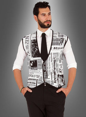 Ein Mann in weißem Hemd, schwarzer Krawatte, schwarzer Hose und der „Weste Zeitung für Herren schwarz-weiß“ – einer auffälligen schwarz-weißen Weste mit Zeitungsdruck – steht vor einem grauen Hintergrund mit Farbverlauf.