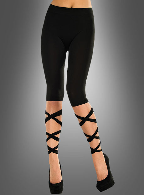 Eine Person, die „Sexy Leggings mit Bändern, schwarz“ – schwarze Capri-Leggings mit eleganten, kreuz und quer verlaufenden Bänderdetails an den Unterschenkeln – und schwarze High Heels trägt, vor einem grauen Hintergrund mit Farbverlauf.
