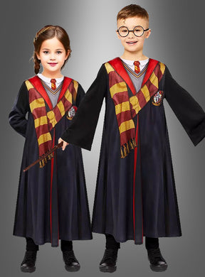 Zwei Kinder, gekleidet in die bedruckte Harry-Potter-Robe mit Zauberstab und Brille – bestehend aus schwarzen Hogwarts-Schuluniformmänteln, gestreiften Schals und Krawatten –, stehen vor einem grauen Hintergrund – das eine hält einen Zauberstab in der Hand, das andere trägt eine runde Brille.