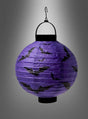 Die LED-Halloween-Papierlaterne „Fledermaus oder Spinnen“ – eine violette Laterne, die mit schwarzen Fledermaus-Silhouetten verziert ist und an einem schwarzen Haken hängt – leuchtet hell als leuchtender Lampion vor einem grauen Hintergrund mit Farbverlauf und ist damit die perfekte, auffällige Halloween-Dekoration.