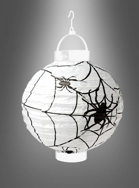LED-Halloween-Papierlaterne „Spinne“ aus rundem weißem Papier, verziert mit schwarzen Spinnennetz- und Spinnenmotiven – perfekt als leuchtender Lampion für Ihre Halloween-Dekoration, aufgehängt an einem weißen Kunststoffhaken vor einem grauen Farbverlaufshintergrund.