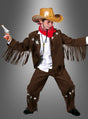 Ein Kind trägt das Cowboy-Bud-Kinderkostüm mit Hut, rotem Halstuch, einer Jacke und einer Hose mit Fransen im Wildleder-Look sowie einer Spielzeugpistole und posiert vor einem grauen Hintergrund.