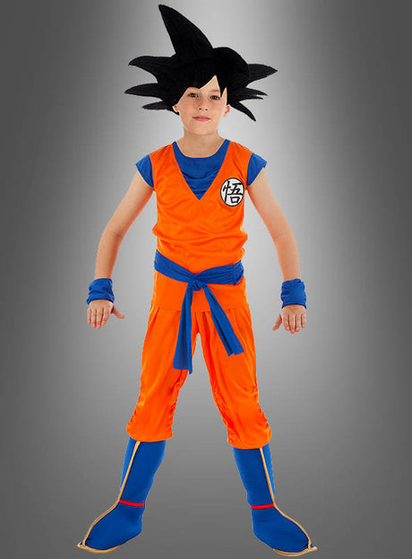 Ein Kind im Son-Goku-Kostüm für Kinder aus „Dragon Ball Z“ – bestehend aus einem orange-blauen Kampfsportanzug und einer schwarzen Perücke mit Stacheln – steht vor einem grauen Hintergrund mit Farbverlauf. Ideal für junge „Dragon Ball Z“-Fans und perfekt für ein Goku-Cosplay.