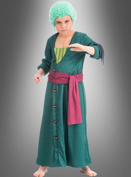 Eine Person, die das Zoro-Kostüm für Kinder aus „One Piece“ trägt – bestehend aus einem grünen Gewand, einer roten Schärpe und einer grünen Perücke –, steht barfuß vor einem grauen Hintergrund und nimmt mit einem nach vorne ausgestreckten Arm eine beeindruckende Anime-Cosplay-Pose ein.