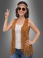 Eine Frau mit Sonnenbrille und Stirnband präsentiert die „Hippie Fransenweste mit Zubehör Damen“ über einem weißen Tanktop und Jeans und macht vor einem grauen Hintergrund das Peace-Zeichen.