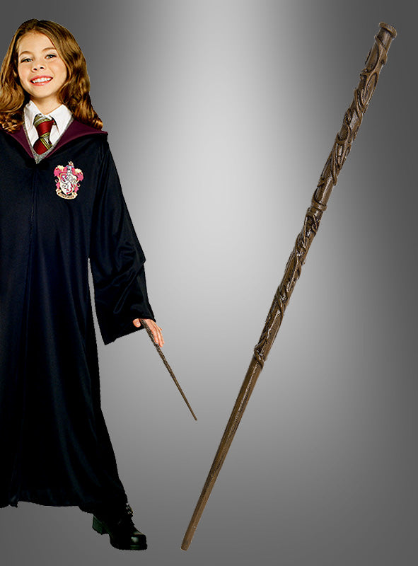 Eine Person in einer schwarzen Robe mit Wappen hält einen kleinen Zauberstab in der Hand, der an die legendären Harry-Potter-Zauberstäbe erinnert; daneben ist der „Hermine Deluxe Zauberstab Harry Potter“ vor einem grauen Hintergrund mit Farbverlauf deutlich zu sehen.
