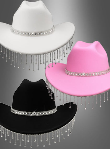 Drei Cowboy-Hüte mit funkelndem Strass in Weiß, Rosa und Schwarz – jeweils mit Strassbändern und schimmernden silbernen Perlenfransen – sind vor einem grauen Hintergrund mit Farbverlauf zu sehen. Diese stilvollen Hüte sind das perfekte Festival-Accessoire und verbinden gekonnt klassischen Western-Charme mit modernem Glanz.