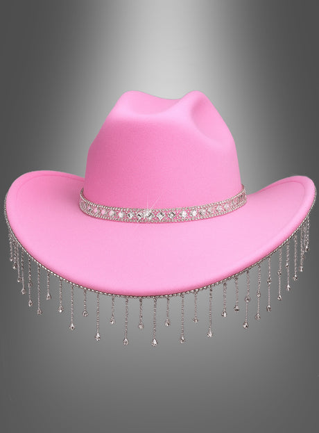 Der „Cowboy Hut mit funkelndem Strass“ ist ein stilvoller rosa Hut mit einem funkelnden Strassband und herabhängenden silbernen Kettenquasten vor einem grauen Farbverlauf – perfekt als Festival-Accessoire oder als auffälliger Cowboy-Hut für Damen.