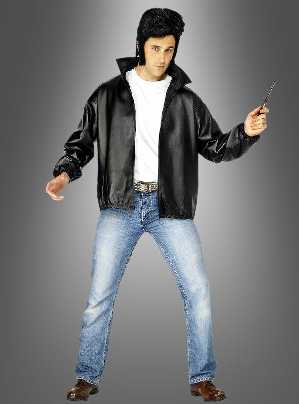 Eine Person, die eine schwarze T-Bird-Jacke im Grease-Stil der 60er Jahre trägt, dazu ein weißes T-Shirt, blaue Jeans und braune Schuhe, hält ein Springmesser in der Hand, während sie vor einem grauen Hintergrund mit Farbverlauf steht.