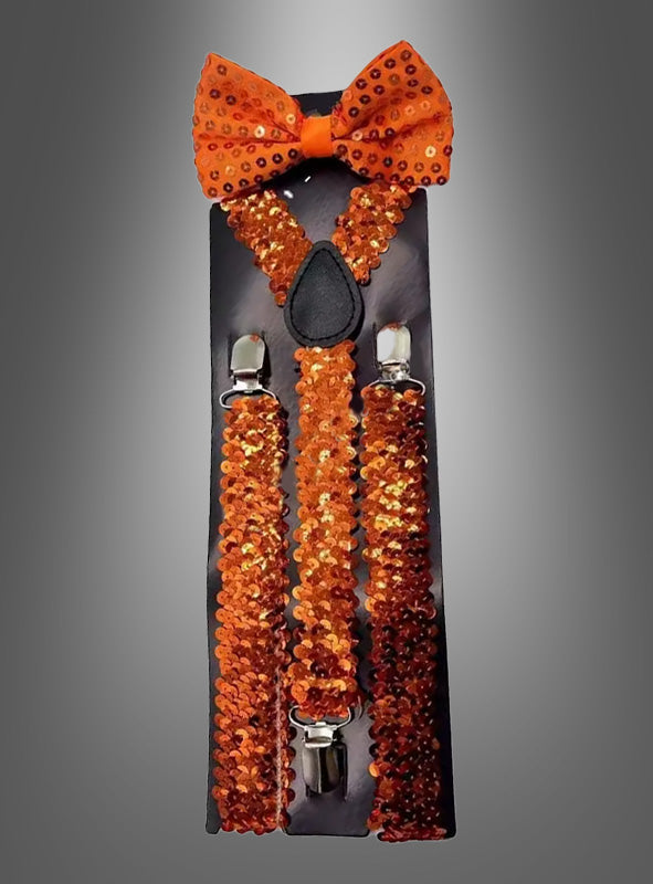 Pailletten-Hosenträger mit Fliege im Set in Orange, präsentiert auf einer schwarzen Karte vor einem grau verlaufenden Hintergrund – ein auffälliges Karnevals-Kostüm-Accessoire, das garantiert alle Blicke auf sich zieht.