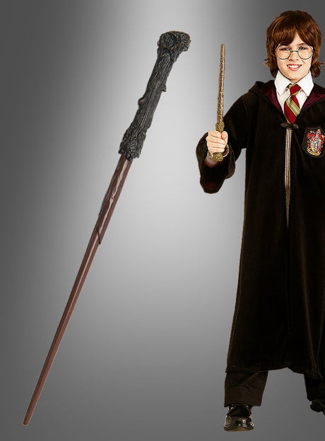 Eine Person in einer schwarzen Robe und einer rot gestreiften Krawatte hält einen „Deluxe Zauberstab Harry Potter“ in der Hand, während links auf einem grauen Hintergrund mit Farbverlauf ein weiterer Zauberstab vergrößert abgebildet ist.