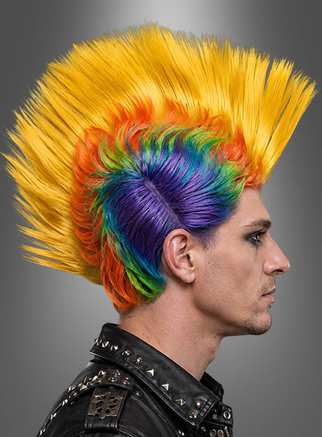 Eine Person im Profil mit einem hohen, stacheligen Irokesenschnitt in Regenbogenfarben, die eine schwarze Lederjacke mit Metallnieten trägt – perfekt für den Karneval oder als auffällige bunte Punk-Perücke im Irokesen-Stil – vor einem grauen Hintergrund mit Farbverlauf.