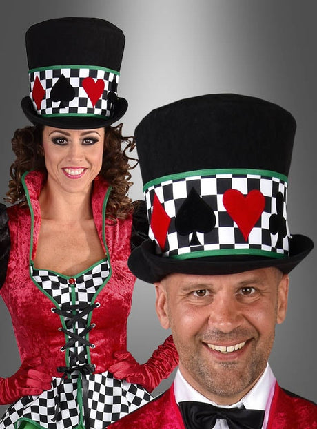 Zwei Erwachsene tragen die schwarzen „Casino Hut Stoff Zylinder Unisex“-Zylinder mit Kartensymbolen und Schachbrettmustern sowie dazu passende rote und grüne „Las Vegas Party Kostüm“-Outfits, während sie selbstbewusst vor einem schlichten grauen Hintergrund posieren.