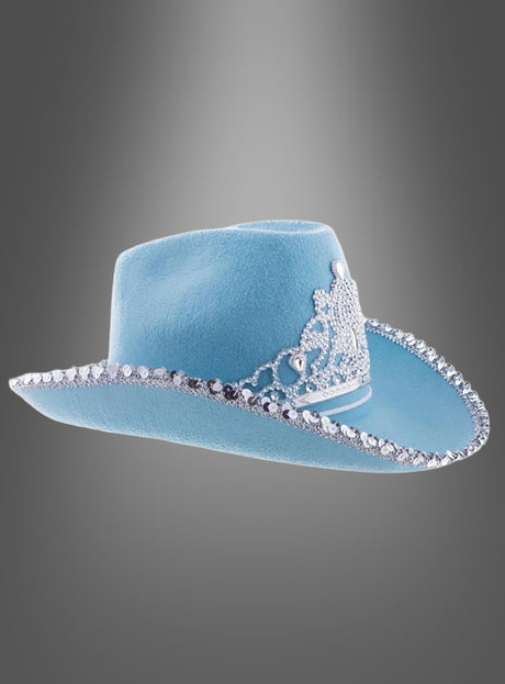 Produktbeschreibung: Der „Cowgirl Hut mit Krone“ ist hellblau und mit funkelnden silbernen Strasssteinen am Rand verziert; an der Seite ziert ihn ein silbernes Kronen-Emblem. Er wird vor einem eleganten grauen Hintergrund mit Farbverlauf präsentiert.