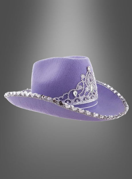 Eine lavendelfarbene Cowgirl-Hut mit Krone, verziert mit funkelnden silbernen Pailletten am Rand und einem glitzernden, mit Edelsteinen besetzten Tiara-Motiv auf der Vorderseite, präsentiert vor einem grauen Hintergrund mit Farbverlauf.