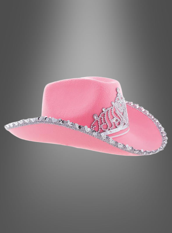 Cowgirl-Hut mit Krone in Rosa, verziert mit einer silbernen Paillettenborte und einem funkelnden Strass-Tiara-Akzent auf der Vorderseite, präsentiert vor einem grauen Hintergrund mit Farbverlauf.