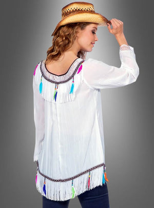 Eine Person in einem weißen, mit bunten Federn verzierten Oberteil mit Fransen und einem Cowboyhut, von hinten vor einem grauen Hintergrund gesehen – sie verkörpert perfekt den Bohemian-Charme der „Hippie-Tunika mit Federn und Fransen“.