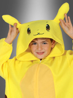 Ein Kind lächelt, während es den gelben Overall „Elektromaus mit Kapuze“ trägt, einen Overall im Kigurumi-Stil mit Kapuze, auf der Pikachus Gesicht und Ohren abgebildet sind, vor einem grauen Hintergrund – die perfekte Wahl für jeden Pokémon-Fan.