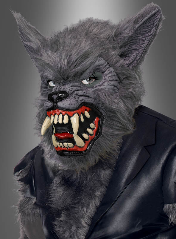 Ein Kind trägt das Werwolf-Kinderkostüm, bestehend aus einer detailreichen grauen Maske mit scharfen Reißzähnen und spitzen Ohren sowie einer schwarzen Jacke vor einem grauen Hintergrund mit Farbverlauf.