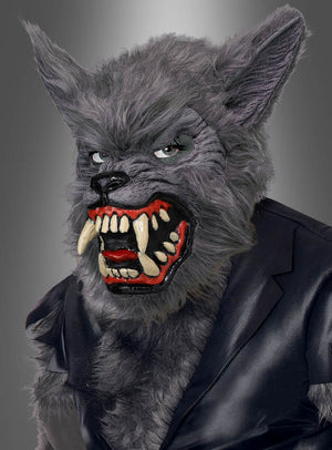 Ein Kind trägt das Werwolf-Kinderkostüm, bestehend aus einer detailreichen grauen Maske mit scharfen Reißzähnen und spitzen Ohren sowie einer schwarzen Jacke vor einem grauen Hintergrund mit Farbverlauf.