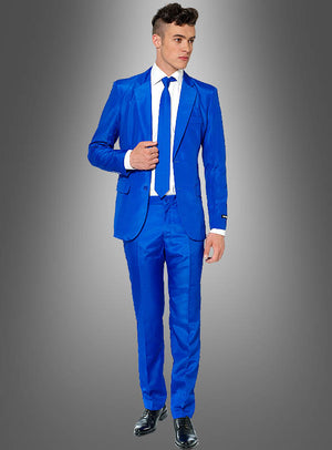 Ein Mann, der einen blauen „Anzug für Herren“ von Suitmeister, ein weißes Hemd und eine blaue Krawatte trägt, steht vor einem grauen Hintergrund mit Farbverlauf.