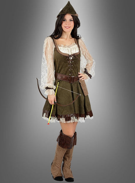 Eine Frau, die das Robin-Hood-Kostüm für Damen mit Spitzenärmeln, einem spitzen Hut und braunen Stiefeln trägt, hält einen kleinen Bogen und einen Pfeil in der Hand, während sie vor einem grauen Hintergrund steht.