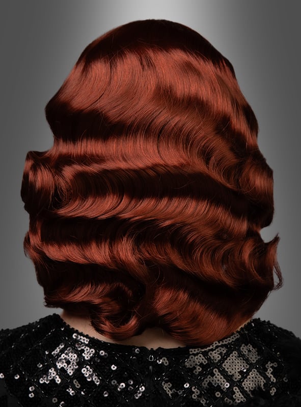 Eine Person ist von hinten zu sehen, die die „Premium Luxus Perücke 20er Wasserwelle Frisur Lilly“ trägt – glänzendes, welliges, schulterlanges rotes Haar, das im klassischen Wasserwellen-Look gestylt ist, kombiniert mit einem schwarzen Top mit Pailletten vor einem grauen Hintergrund mit Farbverlauf.
